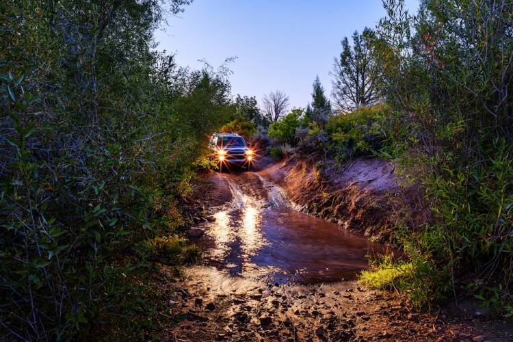 truck driving through mud puddle at night